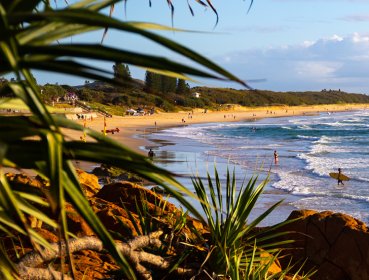 Distant shot of people swimming and surfing in the ocean