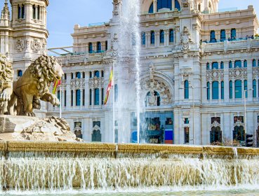 Close up of the lions on the Cibeles Fountain with palace in background