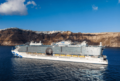 Star Princess sailing past the dramatic clifftop villages of Santorini under a clear blue sky
