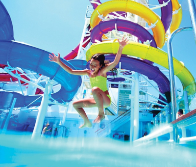 A girl jumps into a pool in a waterpark on board a cruise ship