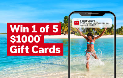 Win 1 of 5 $1000* gift cards. Flight Centre Subscribe - woman playing in the surf framed by a phone