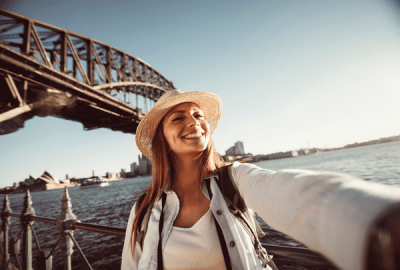 A woman takes a selfie by Sydney Harbour Bridge