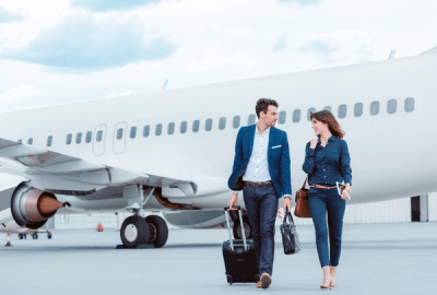 Business colleagues walking on tarmac in front of a plane