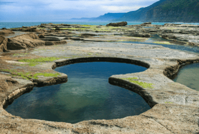 A rock pool cut naturally into a figure-8 with ocean views beyond at Royal National Park, NSW