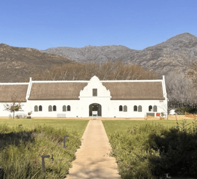 A view of a wine farm's garden and farm house in Cape Town.