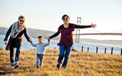 Two women and a young boy holding hands in front of the Golden Gate Bridge in San Francisco