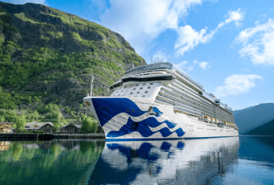 The cruise ship Sky Princess anchors in a fjord in calm waters.
