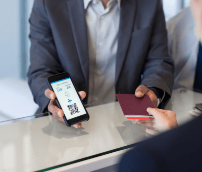 Man displays boarding pass and passport to flight staff
