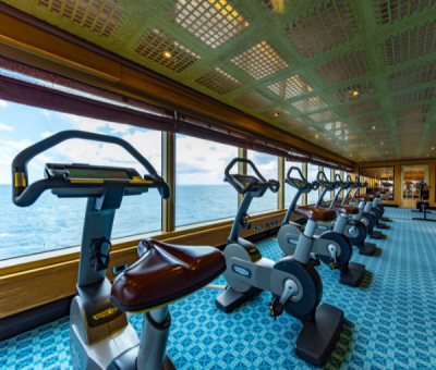 A line of exercise bikes looking out over the sea on a cruise ship
