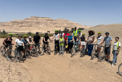 Cyclists stop for a photo with the Valley of the Kings in the Background