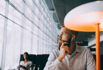 Thoughtful businessman looking away while sitting at an airport departure lounge