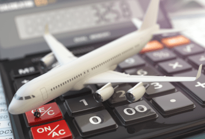 A model jet airliner sits on an accounting calculator