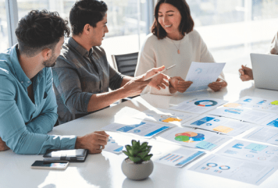 A group of business people gathered around a table discussing an accounting presentation