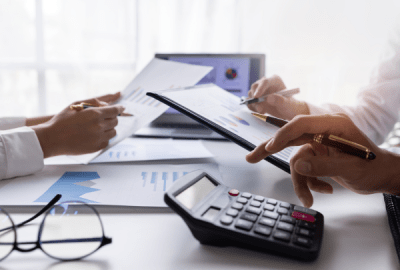 A group of business people gathered around a table discussing an accounting presentation