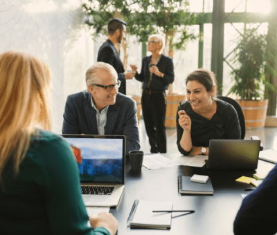 Smiling businesswoman discussing with colleagues in creative office