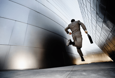 A businessman runs down an urban alleyway
