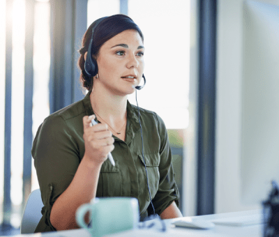 A woman wearing a headset talks with a customer