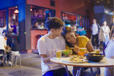 A young couple enjoy beer with their meal at a bar