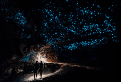 Couple standing underneath Glow Worm Sky in Waipu Cave, New Zealand