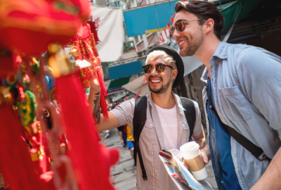 Two young men examine lanterns at a street market