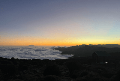A layer of cloud viewed from above gathers around the foothills of Mount Kilimanjaro