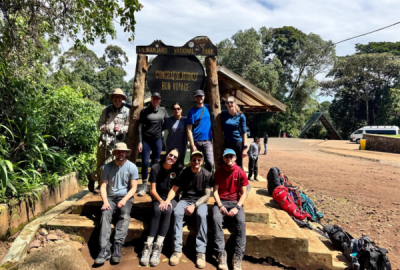 A hiking group gathers at the end point of the hike up Mount Kilimanjaro