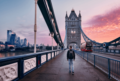 A man walks over Tower Bridge during a colourful London sunrise