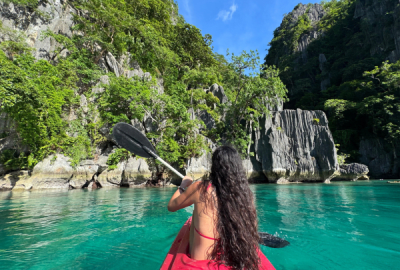 Kayaking the still, green waters around the rocky shoreline of Palawan Island