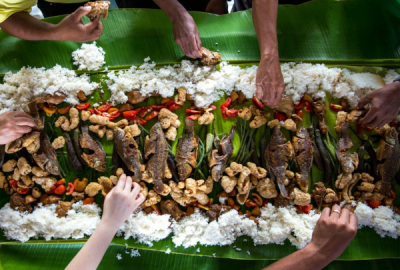 A traditional Filipino feast is shared by many hands