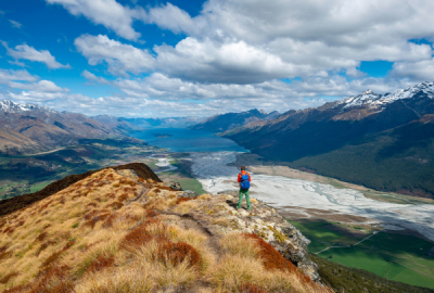 Hiker on the summit of Mount Alfred, views of Lake Wakatipu and mountain scenery near Glenorchy