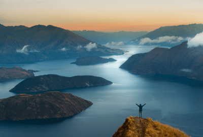Woman overlooks Lake Wanaka from Coromandel peak at sunrise
