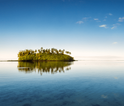 An islet on the horizon of glassy-still lagoon