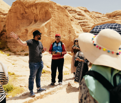 People listen to a tour guide in the desert