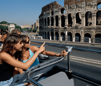 People look at colosseum from a tour bus