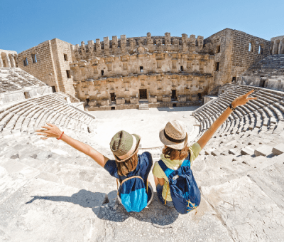 Two women stand with their arms up in the colosseum