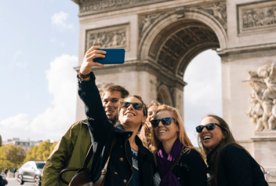 A group of friends pose for a selfie by the Arc de Triomphe