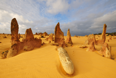 Tall rock formations amid yellow desert sands