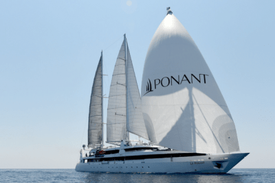 A large yacht with the word 'PONANT" emblazoned on its spinnaker