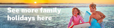See more family holidays here - kids holding kickboards in the ocean at sunset