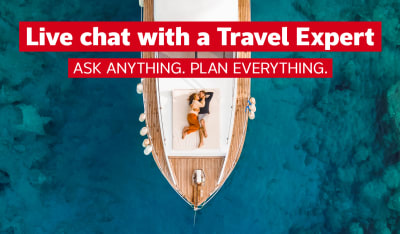 Live chat with a Travel Expert - ask anything, plan everything | Top down shot of a couple lying down, hugging on the deck of a sailboat