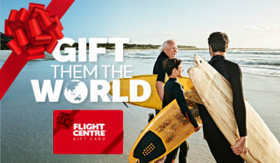 Gift them the world - flight centre. Grandfather, father and son on a beach ready to go surfing