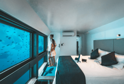 A couple watch fish from underwater in a Reefsuite
