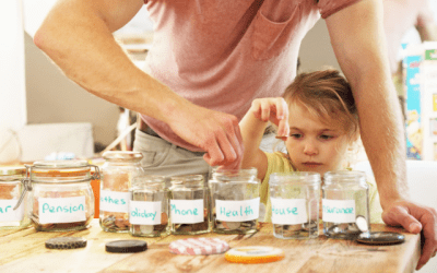 Parent and young child putting coins into labelled money jars