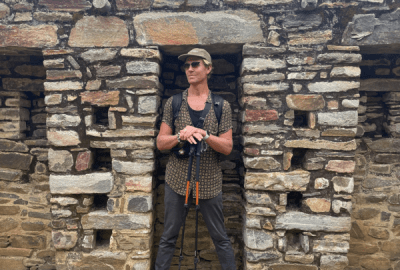 Jacob Stanley stands in a stone alcove among the ruins of the ancient Incan city of Choquequirao, Peru