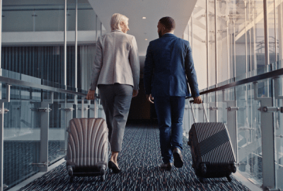 Two business people board a plane from an air-bridge