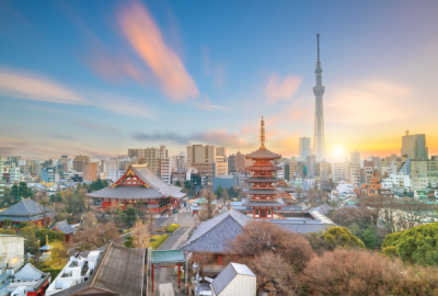 The Tokyo skyline at dawn showing Tokyo Tower in the background, temples in the foreground.