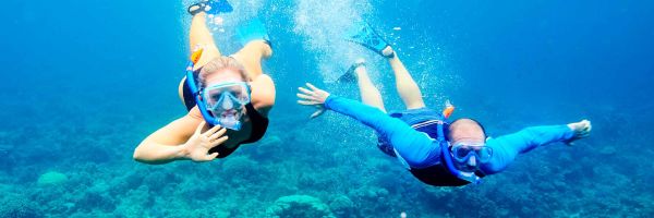 Two people snorkelling through clear blue water