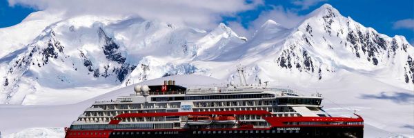 Cruise ship with snow-capped mountains in distance