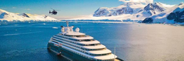 Luxury yacht with snow-capped mountains in distance