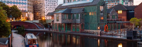 Modern skyscrapers and old wooden buildings along a river in Birmingham